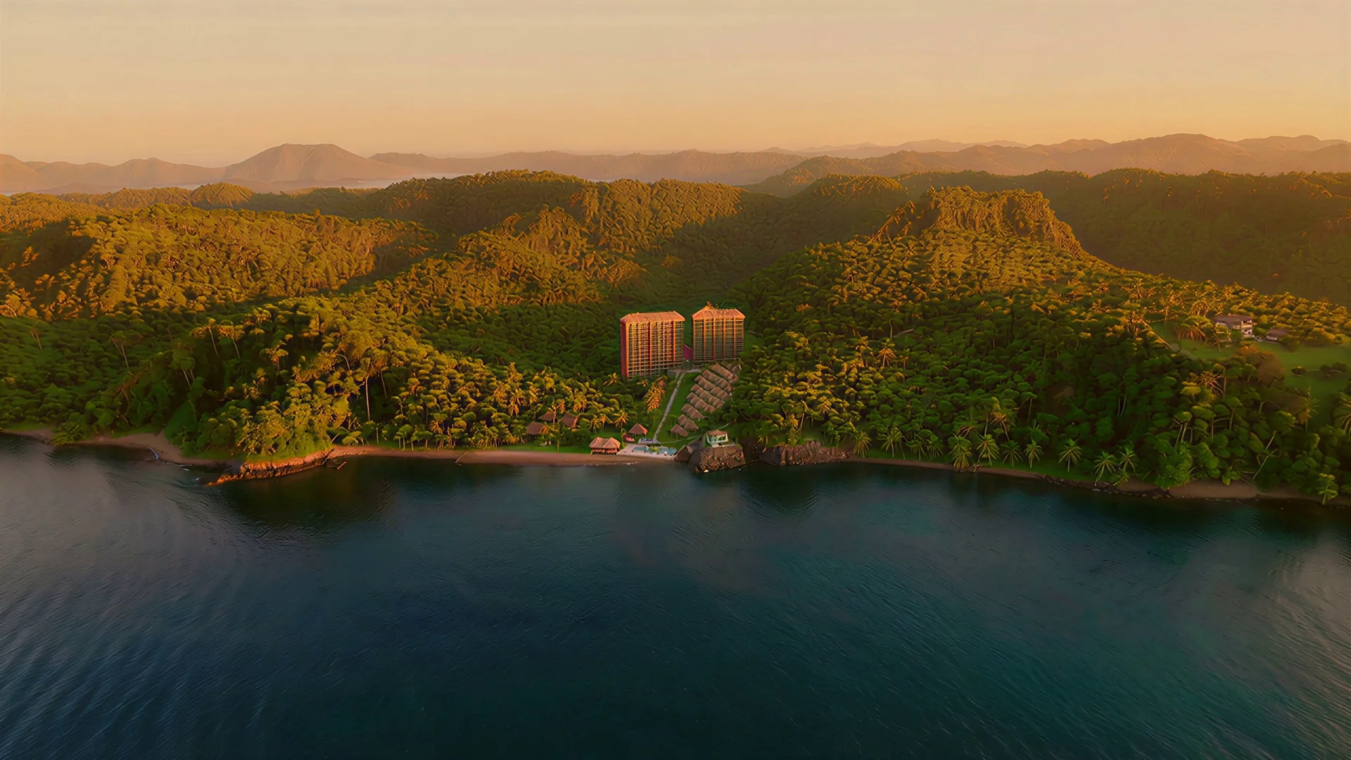 Lago Bravo visto desde el mar al atardecer: el valle con las dos torres bajo sus palapas, las villas y el frente de playa